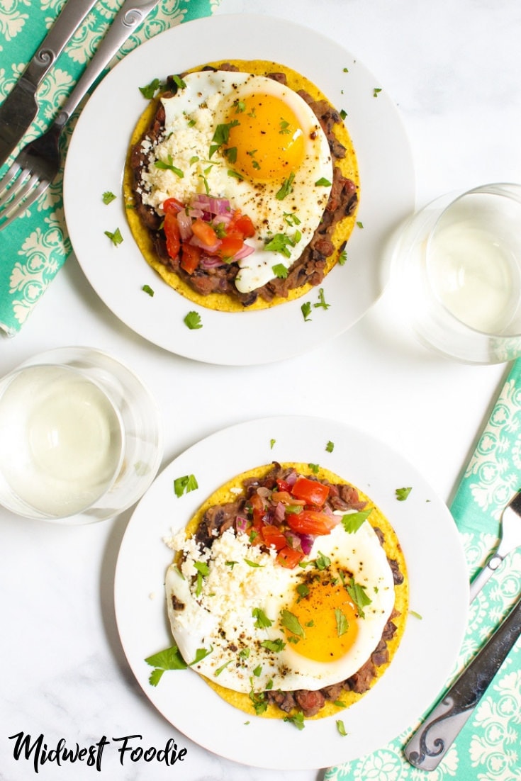 Vegetarian Brunch Tostadas -- Layer tostadas with beans, fry a couple eggs and garnish with cotija cheese and pico de gallo and you’re brunching like a rockstar! Fresh flavors combined with healthy, satisfying, whole ingredients transform your boring breakfast into a memorable brunch experience! #midwestfoodie #healthy #easy #simple #eggs #tostadas #Mexican #vegetarian #fitfamily #familydinner