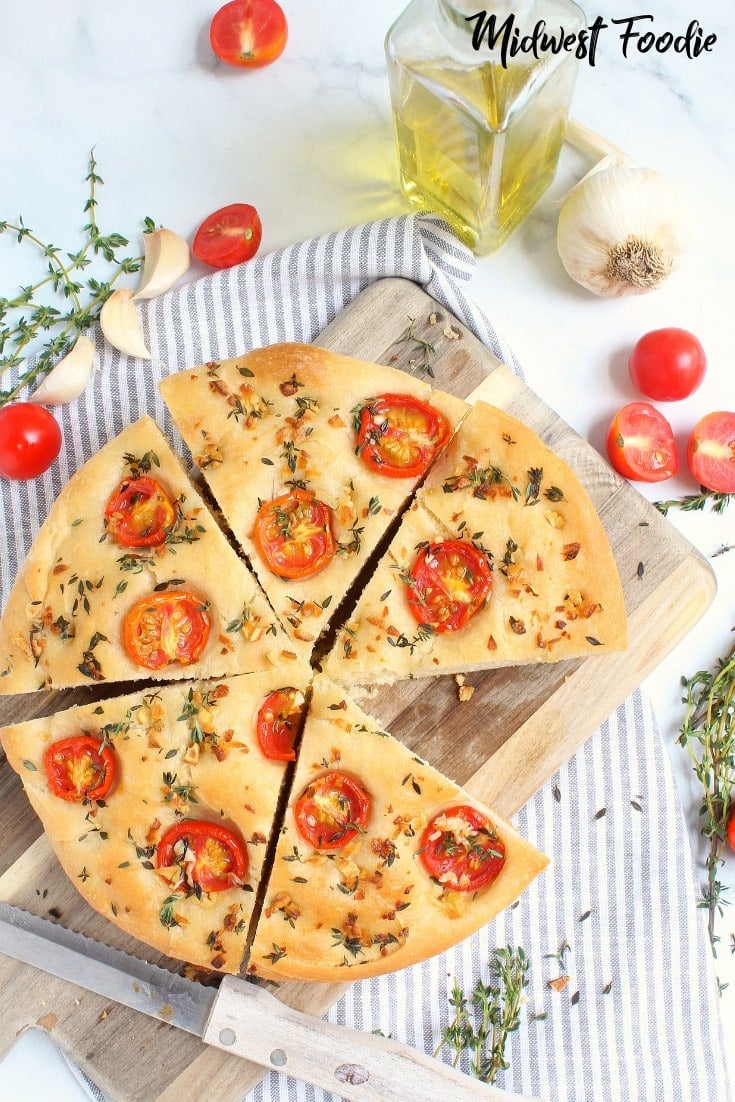 Herb & Tomato Focaccia Bread -- This easy recipe is perfect as an appetizer or works great as a hearty bread for a delicious sandwich! To get the best focaccia bread, drizzle with a generous amount of herb infused olive oil and bake in a pie dish or cast iron skillet. It bakes up crispy on the outside, but super soft on the inside. #midwestfoodie #easy #simple #appetizer #bread #sandwich #castiron #tomato #garlic #herb