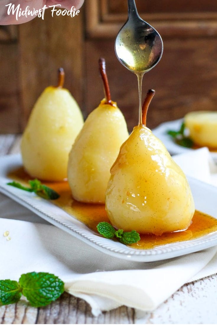 White Wine Poached Pears with Homemade Whipped Cream -- These pears are mouthwateringly tender with just the right amount of sweetness and a pillowy dollop of homemade whipped cream on top. Garnish with fresh mint and watch your guests devour them! #dessert #simple #easy #recipe #partyfood #dinnerparty #summertime #fall #holiday #familydinner
