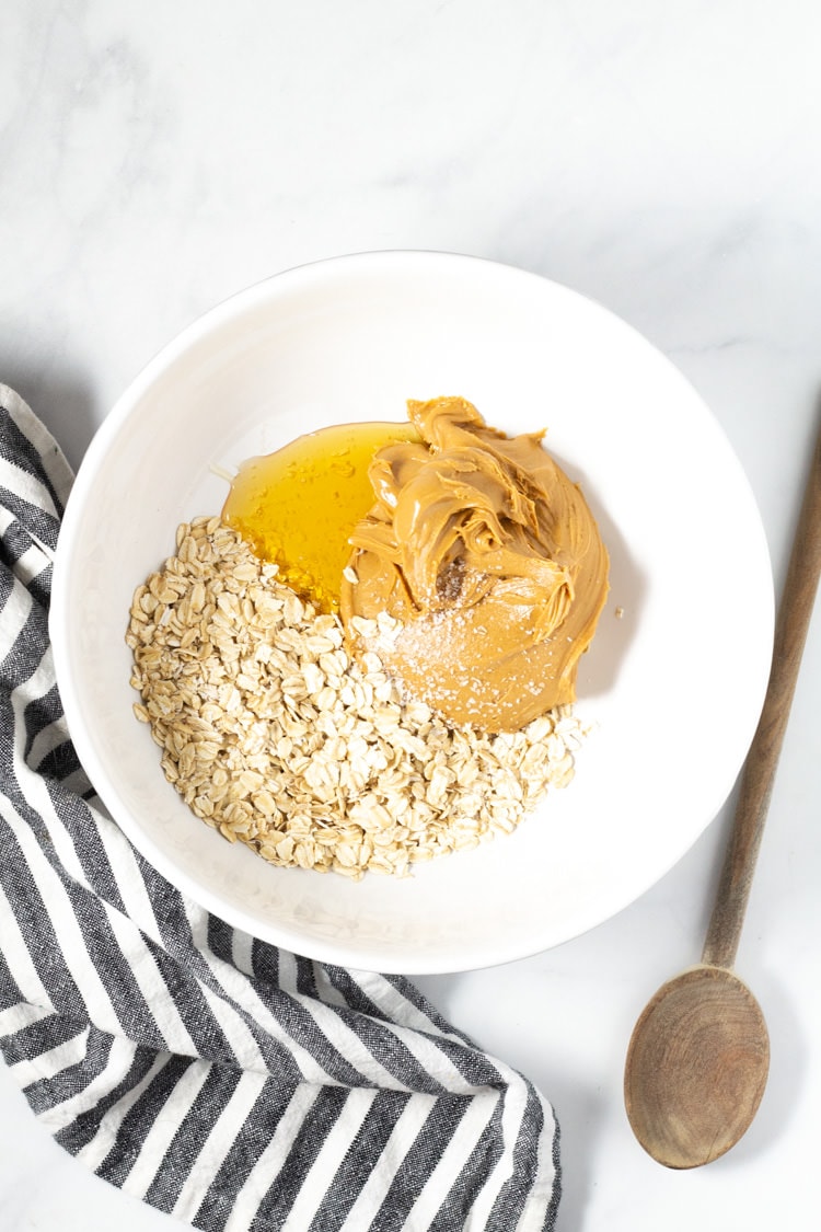 Overhead shot of a white bowl filled with peanut butter oats and honey
