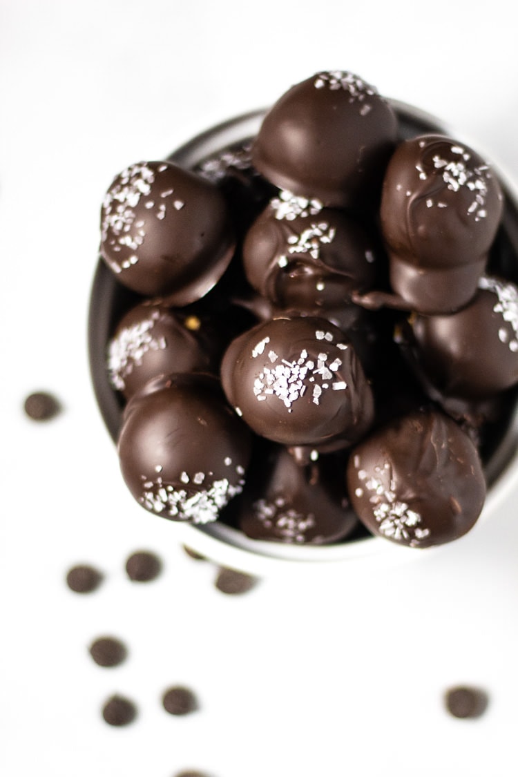 Overhead shot of chocolate covered peanut butter balls garnished with sea salt