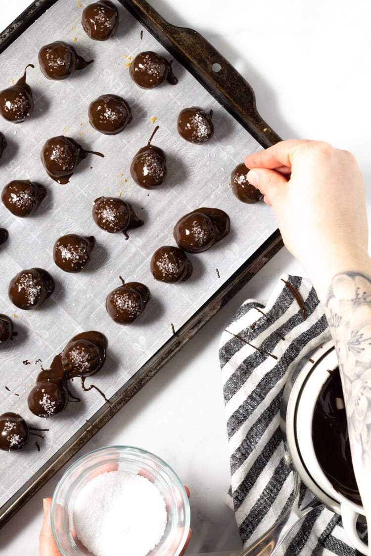 Overhead shot of peanut butter balls being garnished with salt