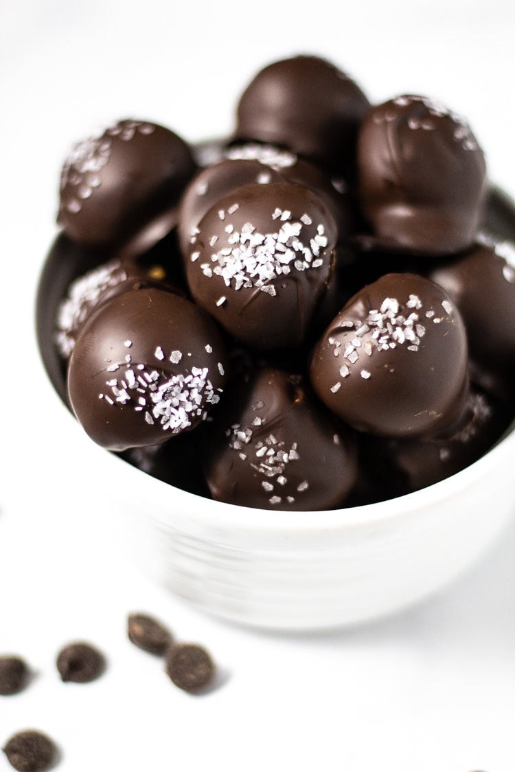 White bowl filled with chocolate covered peanut butter balls