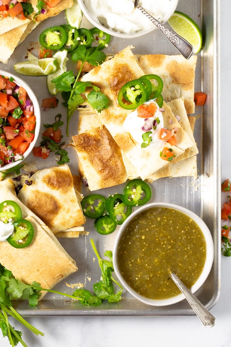 Platter of quesadillas garnished with pico de gallo and jalapenos