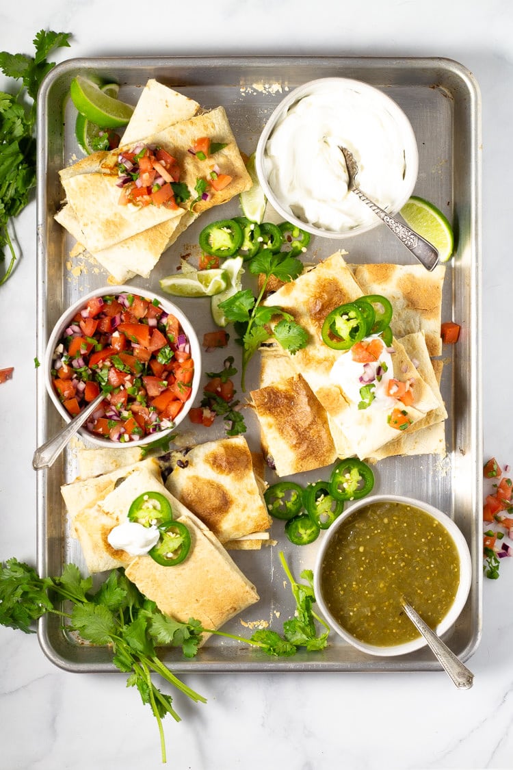 Sheet pan quesadillas garnished with cilantro and jalapenos