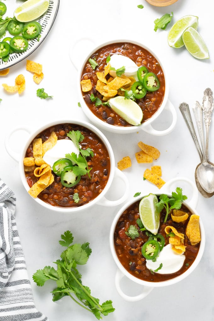 Three white bowls filled with vegan black bean chili