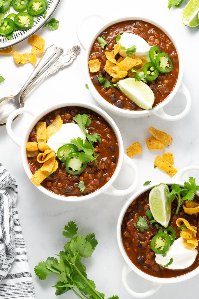 Three white bowls filled with vegan black bean chili