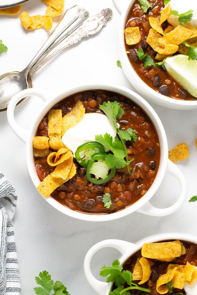 Three white bowls filled with vegan black bean chili