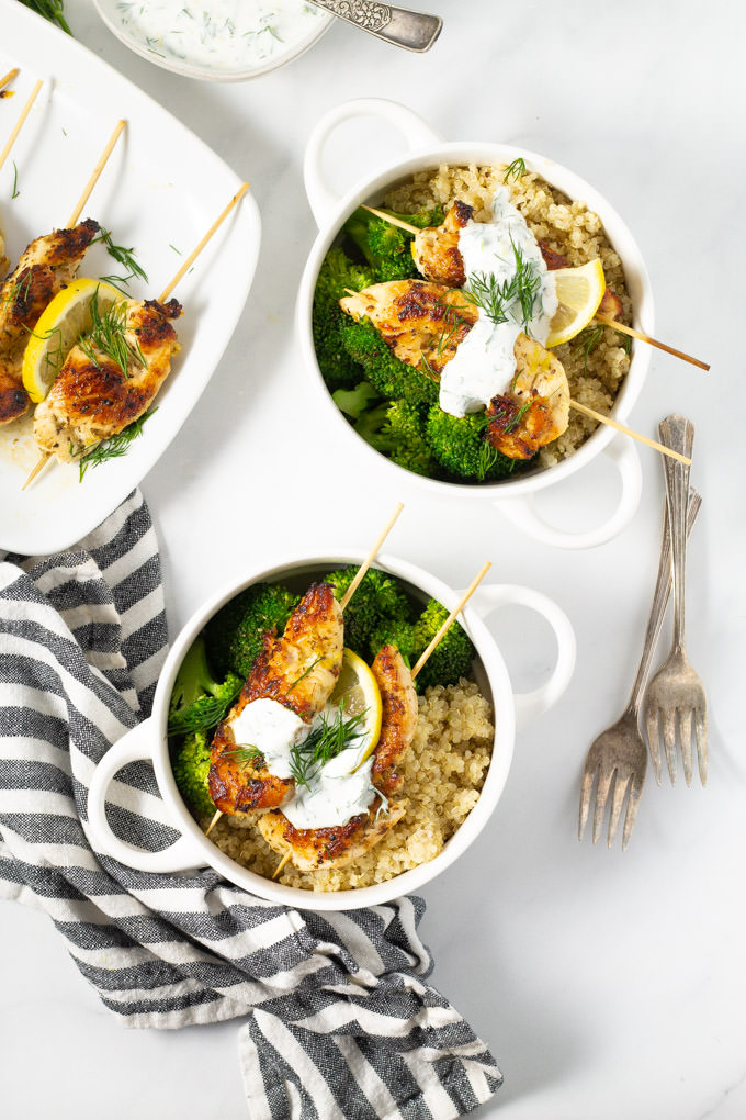 White bowl filled with Greek chicken kebabs quinoa and broccoli