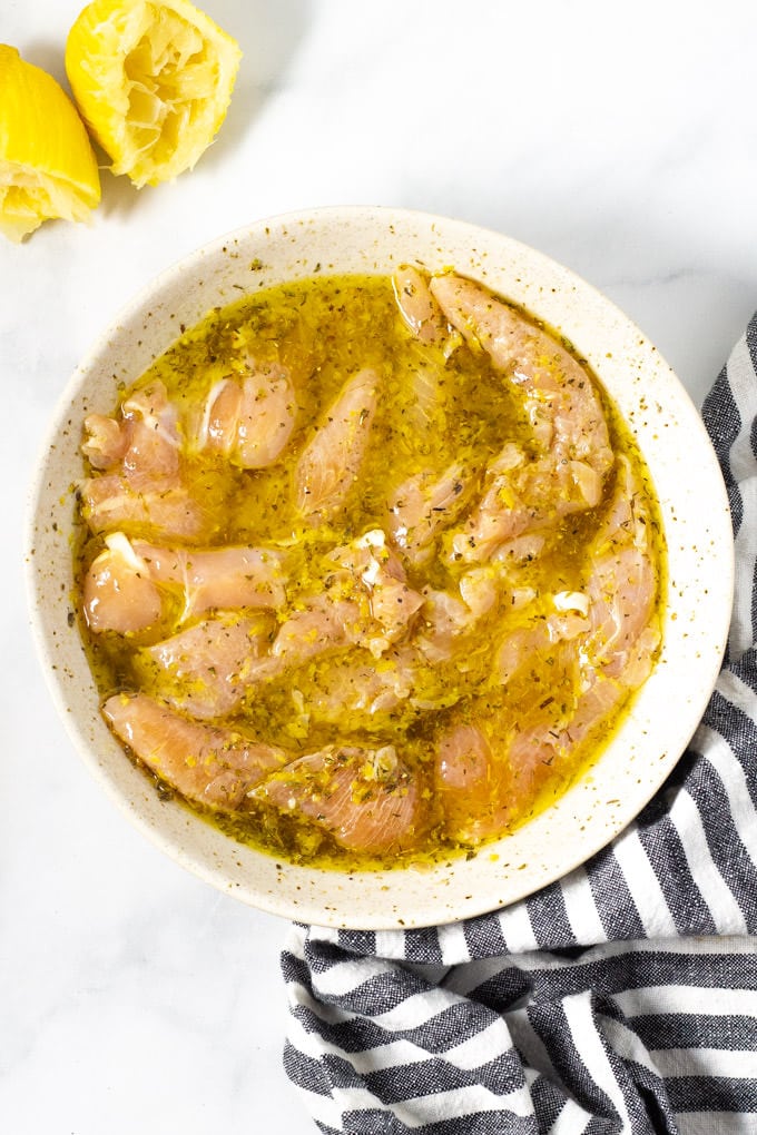 Chicken strips marinating in a bowl