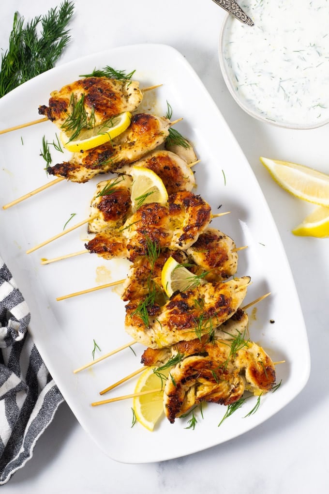 Overhead shot of chicken kebabs on a white platter