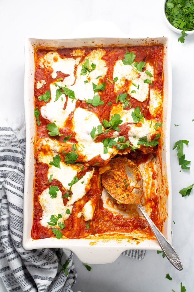 Overhead shot of a pan of freshly baked manicotti with a serving spoon