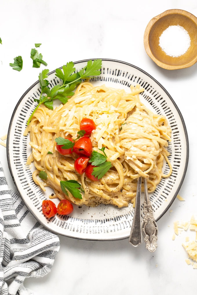 A plate filled with alfredo garnished with fresh parsley