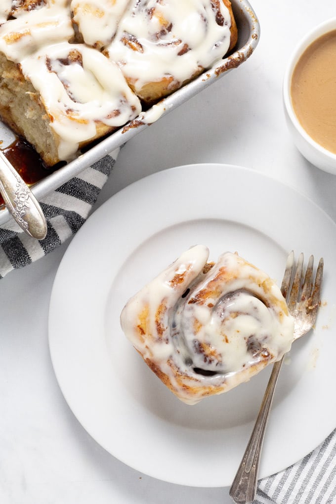 Close up shot of a homemade pizza dough cinnamon roll on a white plate