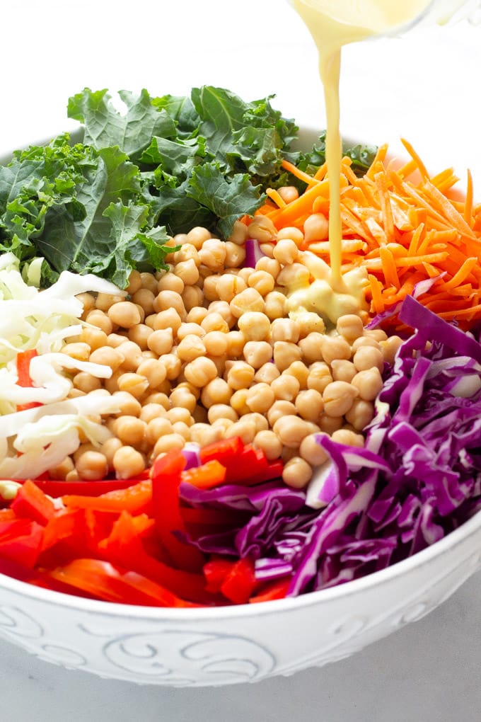 Close up shot of curry dressing being poured over slaw