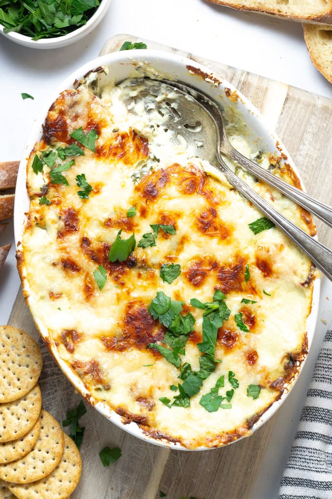 Overhead shot of spinach and artichoke dip garnished with fresh parsley
