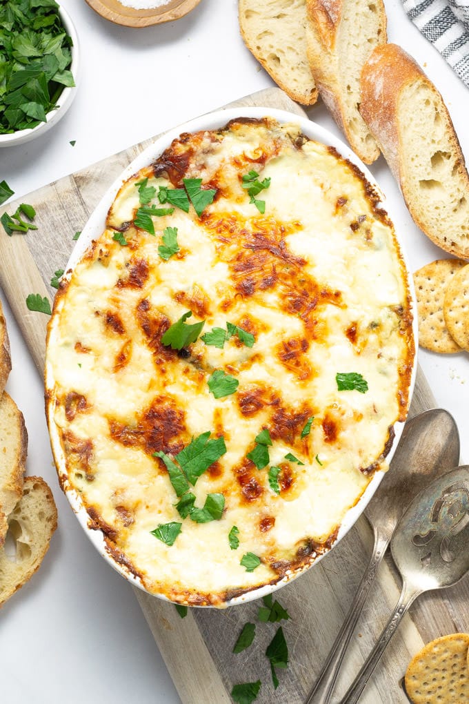 Overhead shot of spinach and artichoke dip garnished with fresh parsley