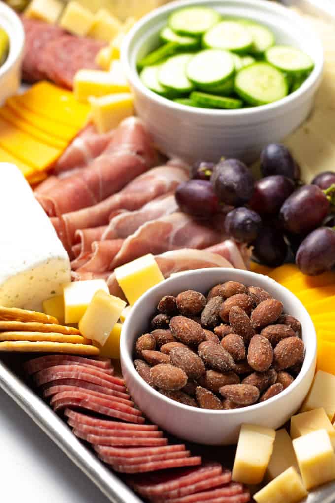 Close up shot of a cheese board filled with cheese meat veggies and fruit
