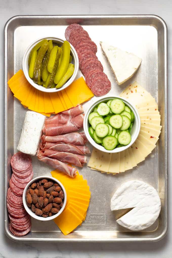 Overhead shot of a baking sheet filled with meat and cheese creating a cheese board