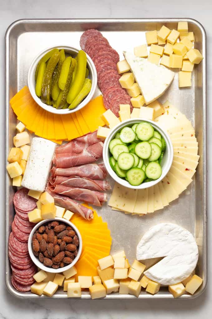 Overhead shot of a baking sheet filled with meat and cheese creating a cheese board