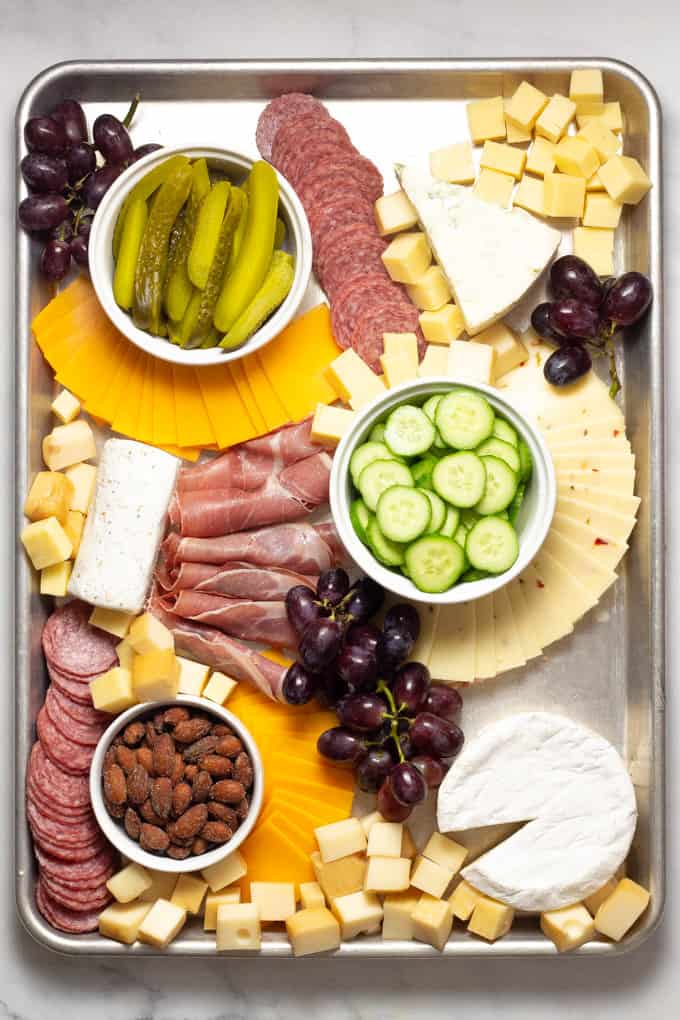 Overhead shot of a baking sheet filled with meat and cheese creating a cheese board