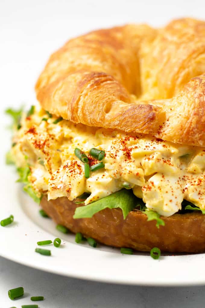 Close up photo of a croissant loaded with deviled egg salad