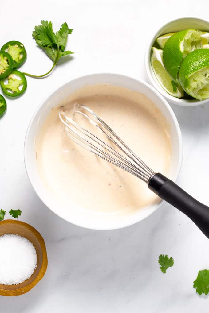 A white bowl filled with fresh made chipotle lime cream sauce