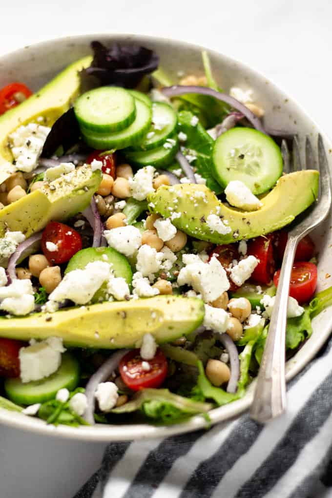 Close up shot of a bowl filled with Greek salad topped with feta cheese