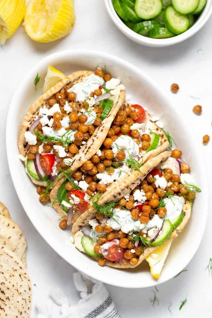Overhead shot of a platter of chickpea gyros loaded with tzatziki and dill