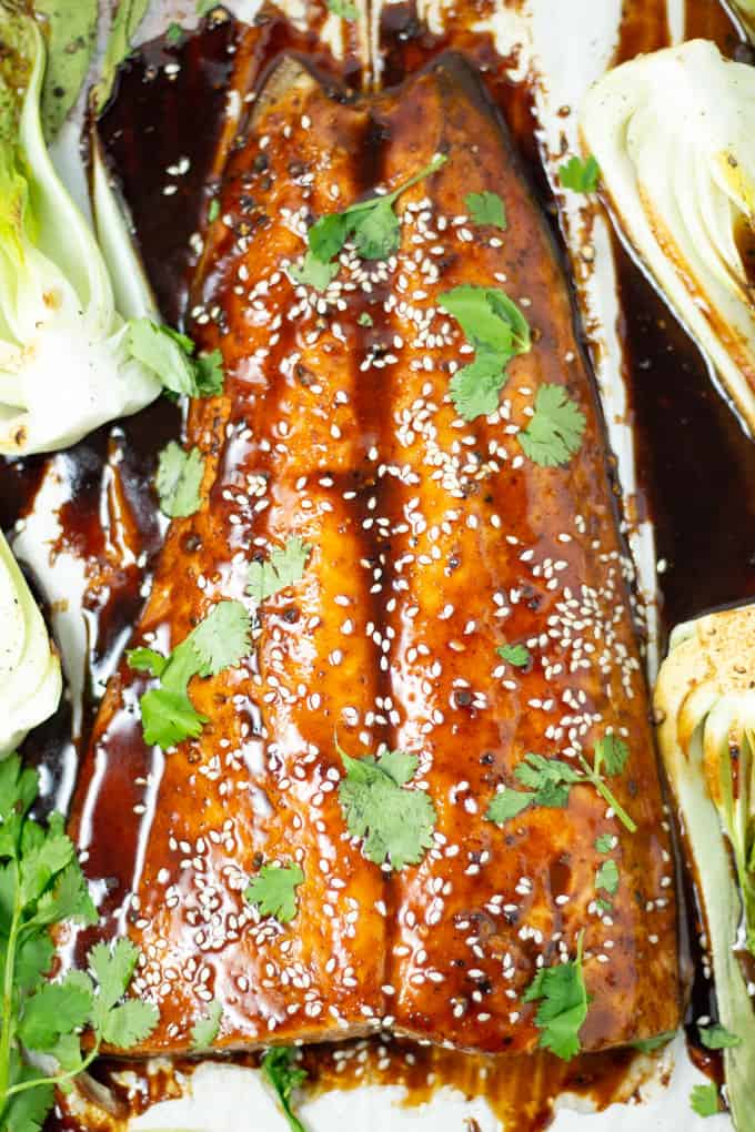 Overhead shot of freshly baked salmon on a baking sheet garnished with cilantro