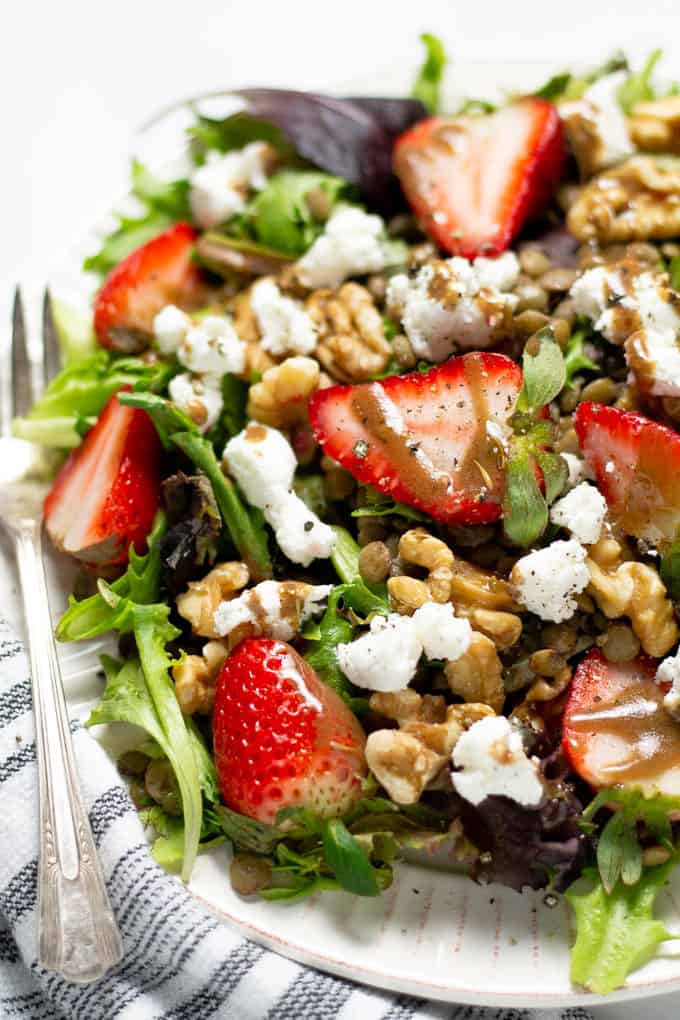 Close up shot of a strawberry salad with goat cheese and balsamic vinaigrette