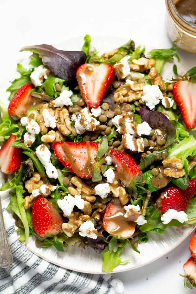 Close up shot of a strawberry salad with goat cheese and balsamic vinaigrette