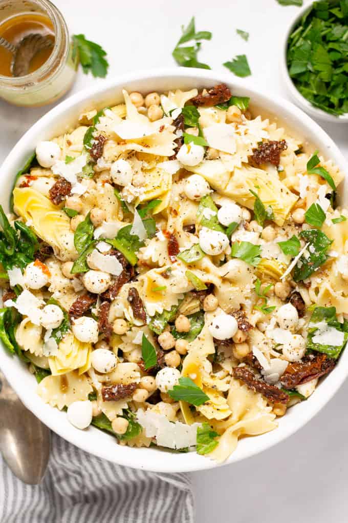 Overhead shot of a bowl of sun dried tomato pasta salad garnished with fresh parsley
