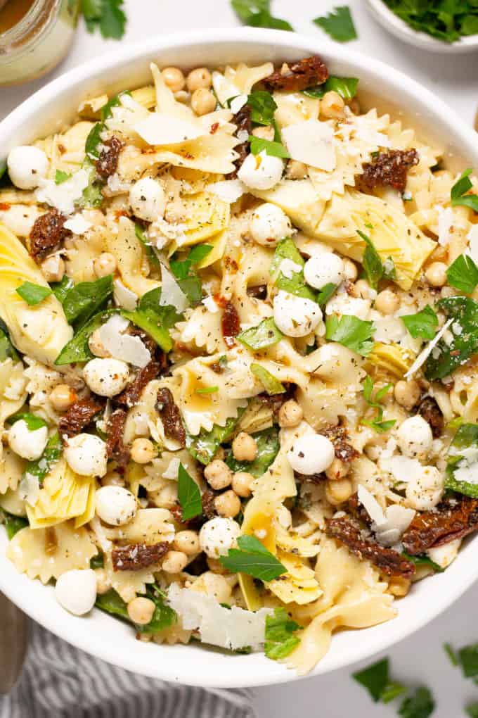 Close up shot of sun dried tomato bowtie salad garnished with parsley
