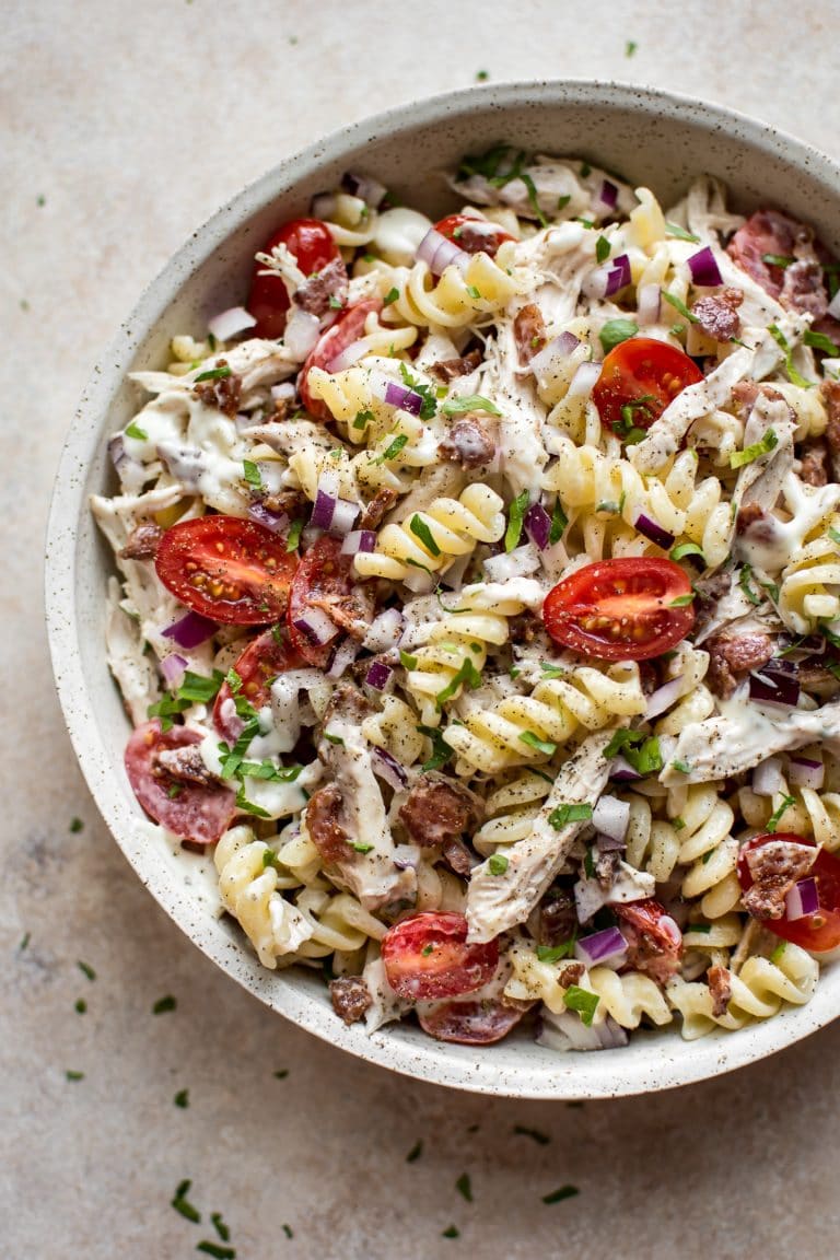 Overhead shot of a chicken ranch pasta with crispy bacon and fresh tomatoes