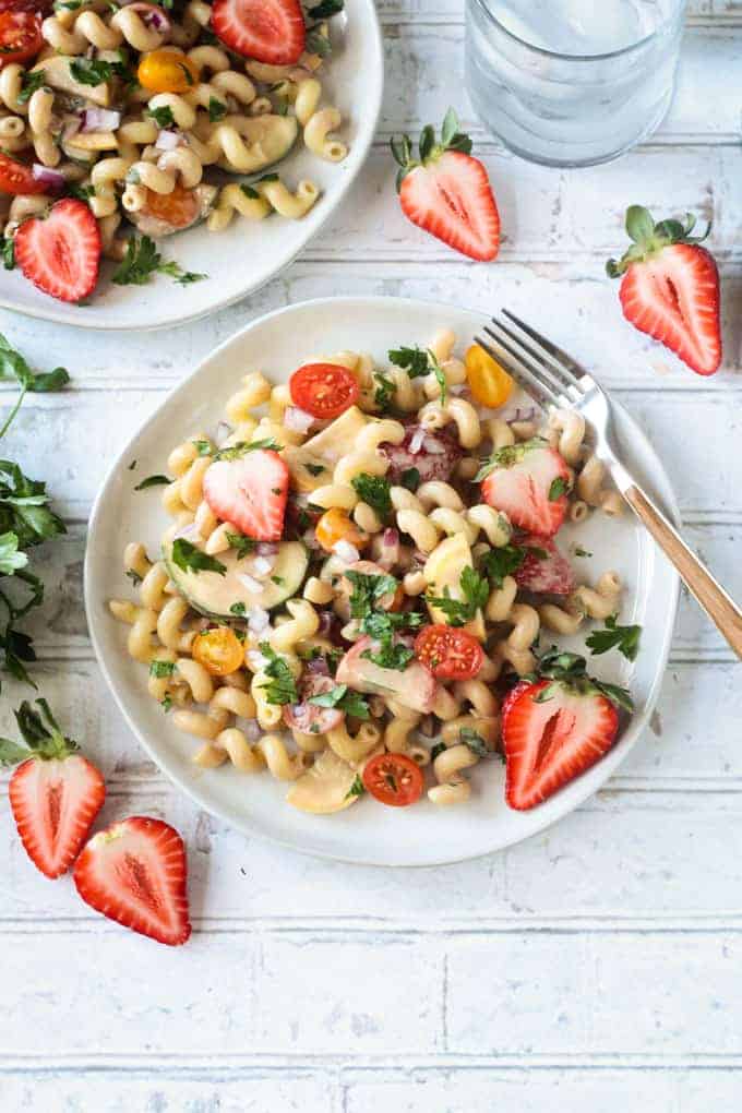Overhead shot of a white plate filled with strawberry balsamic pasta salad