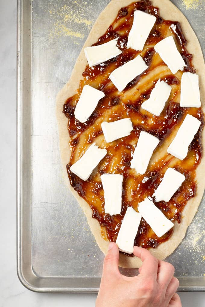 Overhead shot of a flatbread crust with fig jam and brie cheese on it