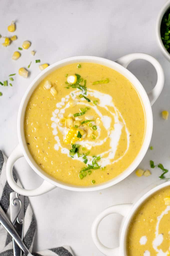 Overhead shot of a bowl of corn chowder garnished with fresh chopped parsley