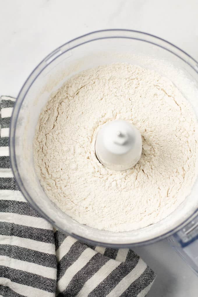 Overhead shot of a food processor filled with flour and salt