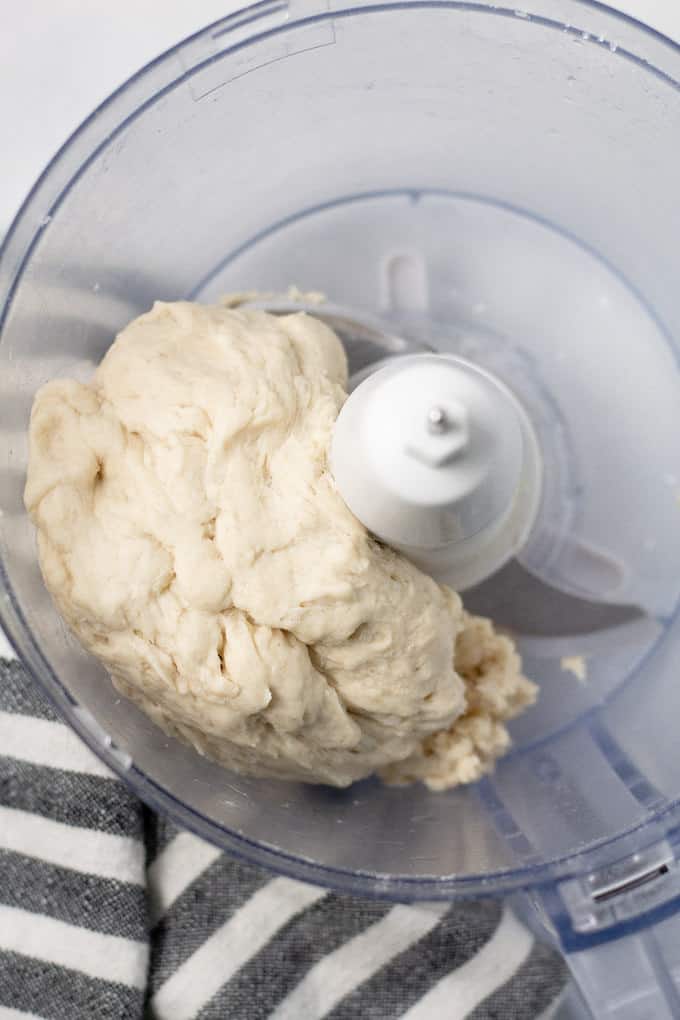 Overhead shot of a food processor with flatbread pizza dough in it