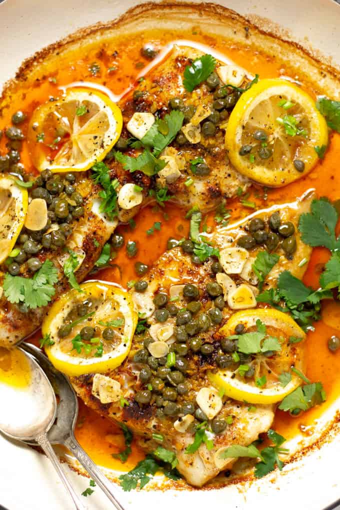 Overhead shot of a pot filled with baked Mediterranean cod garnished with fresh cilantro