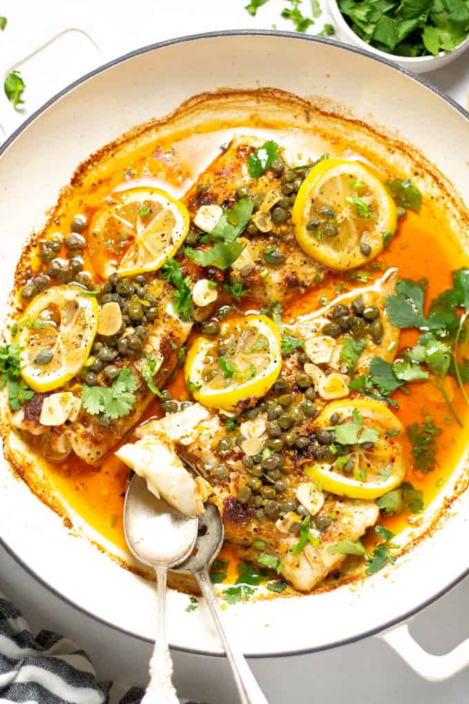 Overhead shot of a pot filled with baked Mediterranean cod garnished with fresh cilantro