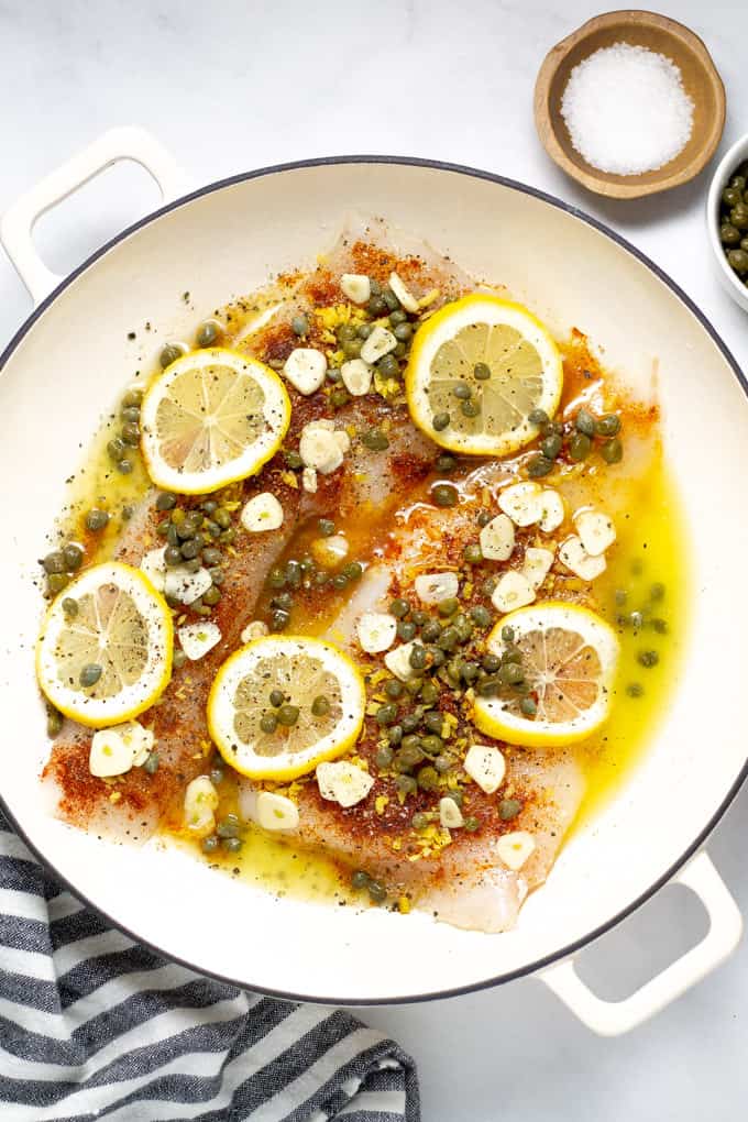 Overhead shot of a pot filled with baked Mediterranean cod garnished with fresh cilantro
