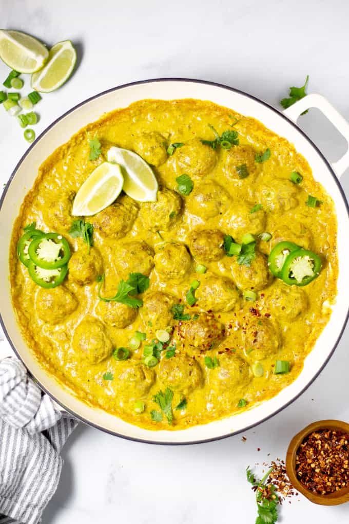 Overhead shot of a pan of curried pork meatballs garnished with fresh cilantro