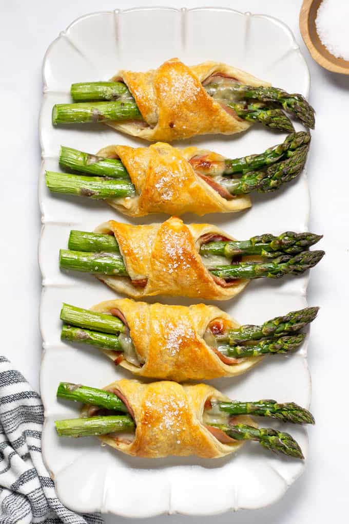 Overhead shot of a white platter filled with puff pastry bundles