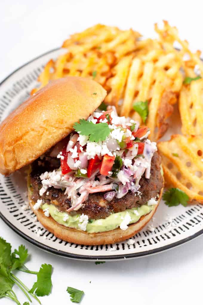 Close up shot of a Mexican burger loaded with chipotle slaw and pico de gallo