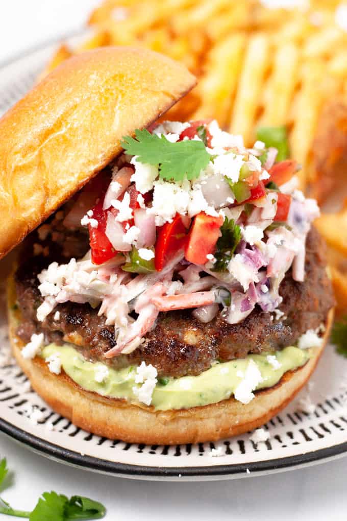 Close up shot of a Mexican burger loaded with chipotle slaw and pico de gallo