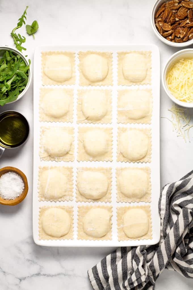 Overhead shot of a large white platter filled with homemade wonton ravioli