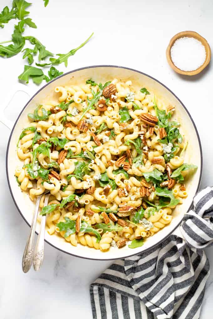 Overhead shot of a white pan filled with fresh homemade Gorgonzola pasta with arugula