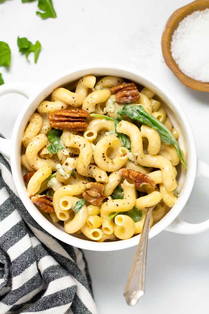 Overhead shot of a white bowl filled with fresh homemade Gorgonzola pasta with arugula